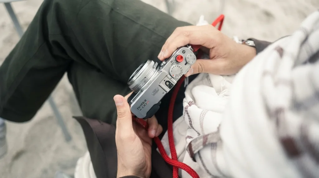 Photographer using a compact camera to take candid travel photos in a vibrant market